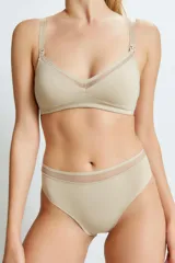 Conjunto de lactancia color beige, compuesto por un corpiño con breteles regulables y broches de lactancia, y una bombacha vedetina con cintura alta y detalle de tul.