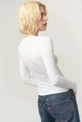 Remera de manga larga color negro, confeccionada en jersey liviano con escote en V y calce ajustado al cuerpo.