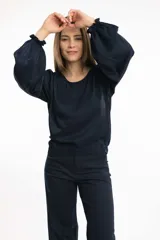 Blusa azul marino con cuello bote y mangas amplias con elástico en los puños.