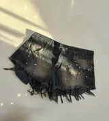 Short de jean negro con tachas doradas y terminación desflecada.