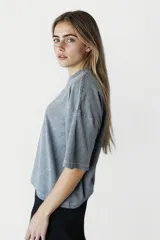 Remera gris oscuro de corte holgado con estampado de una estrella naranja en el pecho.