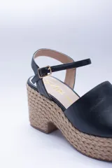 Sandalias negras de cuero con plataforma de yute y pulsera al tobillo.