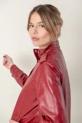 Campera roja de cuero ovino italiano, con charreteras en los hombros, bolsillos laterales, broches ocultos en el frente y broches a la vista en cuello y puños.