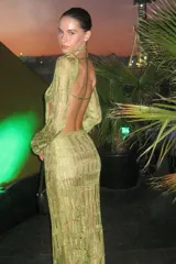 Vestido largo de tejido de punto calado color dorado, con espalda descubierta y mangas largas.