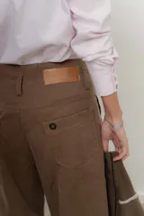 Pantalón marrón de tencel, corte ancho con pinzas y bolsillos laterales.