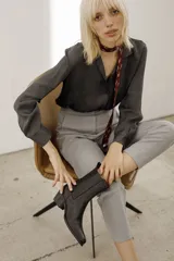 Bota texana de cuero vacuno color negro, con caña media, punta cuadrada y taco bajo.