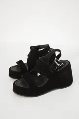 Sandalias negras de plataforma con dos tiras anchas sobre el empeine y hebilla lateral.