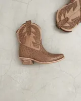 Botas cortas negras de cuero con bordados blancos estilo cowboy.