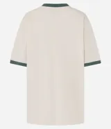 Remera oversize color crema con cuello en V y mangas cortas con ribete verde. Estampado frontal con la palabra "Brooklyn" en verde, el número "98" en bordó con la inscripción "USA" en blanco, y la frase "New York 1998" en blanco.