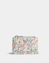 Tarjetero de cuerina con estampado floral multicolor, cierre superior con cremallera y bolsillo frontal abierto.