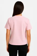 Remera color verde claro de algodón con cuello redondo y mangas cortas. Estampado frontal con dibujo de una pierna estilizada con zapato de tacón y corazones.