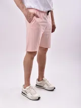 Bermuda de algodón color crudo, corte recto y largo hasta la rodilla, con cintura elástica y cordón ajustable negro.