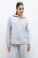 Sweatshirt gris melange con cierre frontal y cuello tipo polo, de manga larga y corte holgado.