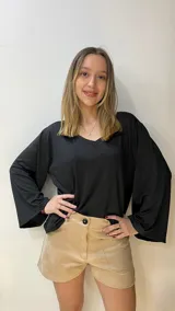 Blusa negra de tela con lycra, escote en V y mangas anchas.