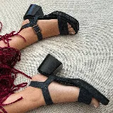 Sandalias de cuero color marrón con plataforma de madera y hebilla dorada.