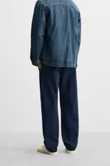 Pantalón azul marino de algodón con corte regular fit, bolsillos delanteros y traseros de vivo, cierre frontal con cremallera y botón.