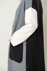 Saco largo en tonos pastel, con diseño combinado de color, dos bolsillos delanteros y cierre con broches.