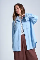 Sobrecamisa negra de gabardina con cuello camisero, cierre frontal con botones, mangas largas con puños abotonados y bolsillos de parche en el pecho.