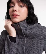 Saco largo de polivelour con textura espina de pez en tonos grises. Tiene cuello alto, capucha, cierre delantero con botón y cremallera, manga larga y bolsillos.