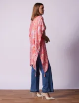 Kimono tejido con estampado abstracto en tonos grises y blancos, con mangas cortas y terminación de ruedo con borlas negras.