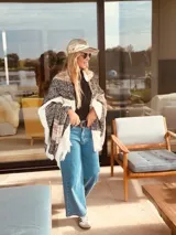 Ruana rectangular tejida en lana con patrón a rayas y flecos. Puede usarse como prenda o como pie de cama.