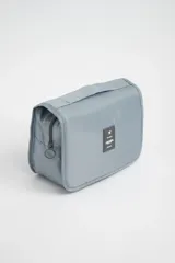 Neceser de viaje azul piedra con gancho para colgar, cierre de cremallera y múltiples bolsillos internos.