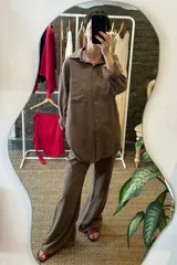 Conjunto de camisa y pantalón color marrón topo, confeccionado en tusor de algodón. La camisa es de corte holgado, con cuello clásico y mangas largas. El pantalón es de corte palazzo, con cintura alta y pierna ancha.