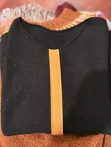 Sweater de cashemere color marrón claro con aplique de cuero ovino en el frente.