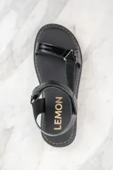 Sandalias negras de cuero con plataforma y tiras ajustables.