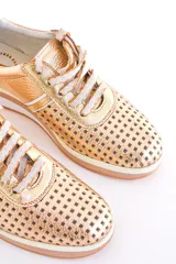 Zapatillas de cuero color dorado con diseño perforado, cordones blancos y suela de goma.