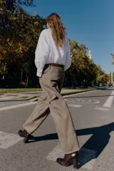 Pantalón cargo de tiro alto color marrón topo, con pierna ancha y holgada que se estrecha hacia el tobillo. Presenta bolsillos delanteros, bolsillo de plastrón lateral y falso bolsillo de vivo en la espalda.