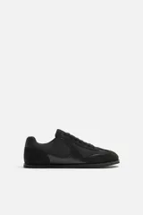 Zapatilla deportiva monocolor negra de cordones, con suela ultrafina y logo lateral.