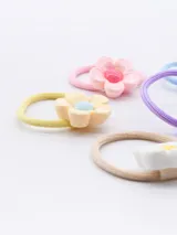 Pack de cinco gomitas de pelo con adorno de flor de plástico en colores pastel: rosa, celeste, lila, amarillo y blanco.