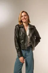 Chaqueta corta de eco cuero negra con tachas plateadas, cuello camisero y cierre frontal con cremallera.