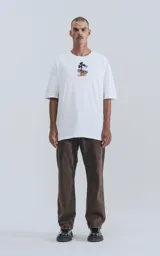 Remera blanca de algodón con cuello redondo y calce oversize. Estampado en la espalda de Mickey Mouse andando en skate con llamas y texto "Hot Diggity Skate Dogs".