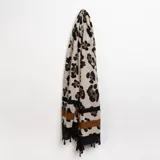 Pashmina color beige con estampado de leopardo en tonos marrón y negro, con borde inferior con diseño de franjas horizontales en negro y marrón, y flecos negros.