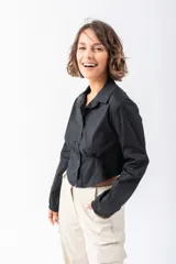 Camisa corta negra de algodón y elastano, con cuello clásico, mangas largas con puños elásticos, cierre frontal con botones y cintura elastizada.