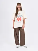 Remera blanca de corte holgado con cuello en V y estampado frontal con la frase 'Los Angeles' y el número '97' en color bordó.