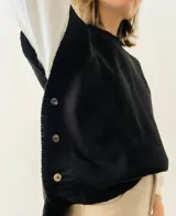 Chaleco negro tejido con botones de nácar en los laterales.
