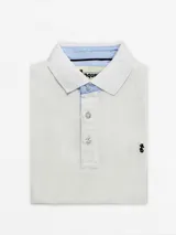 Remera polo de piqué color gris claro, con cuello y borde de mangas blancos y detalles celestes.