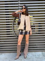 Chaleco color beige con botones y cuello en V.