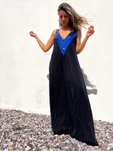 Vestido largo negro de terciopelo con escote en V y apliques de lentejuelas azules en el corpiño.