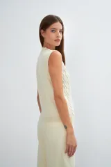 Chaleco tejido marrón con escote en v y sisas amplias. Diseño con diferentes puntos combinados en el frente.