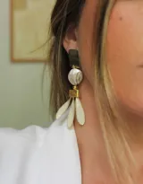 Aros colgantes con forma de flor, con piezas geométricas doradas y pétalos color crema.