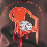 Canguro marrón con capucha, bolsillo delantero y puños y cintura acanalados. Estampado en el pecho con el logo de la marca, una silla y la frase "Sin Siesta No Hay Fiesta".