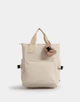 Mochila color crema de tela deportiva con manijas superiores, correas regulables, cierre superior, bolsillos laterales, bolsillo frontal con cierre y pouch estampado extraíble con solapa con hebilla de plástico para cerrado.