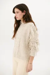 Sweater color arena de tejido de punto con cuello redondo y mangas largas con flecos.