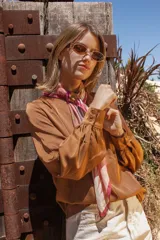 Blusa marrón de mangas largas con puños abotonados y escote en V.