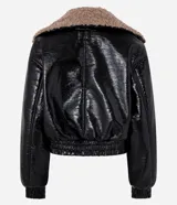 Campera biker negra de cuero sintético con efecto barnizado y cuello de peluche marrón. Tiene cierre delantero cruzado, mangas largas con puños ajustados y bolsillos laterales.
