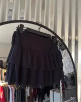 Minifalda negra de tul con cintura alta y volados en capas.